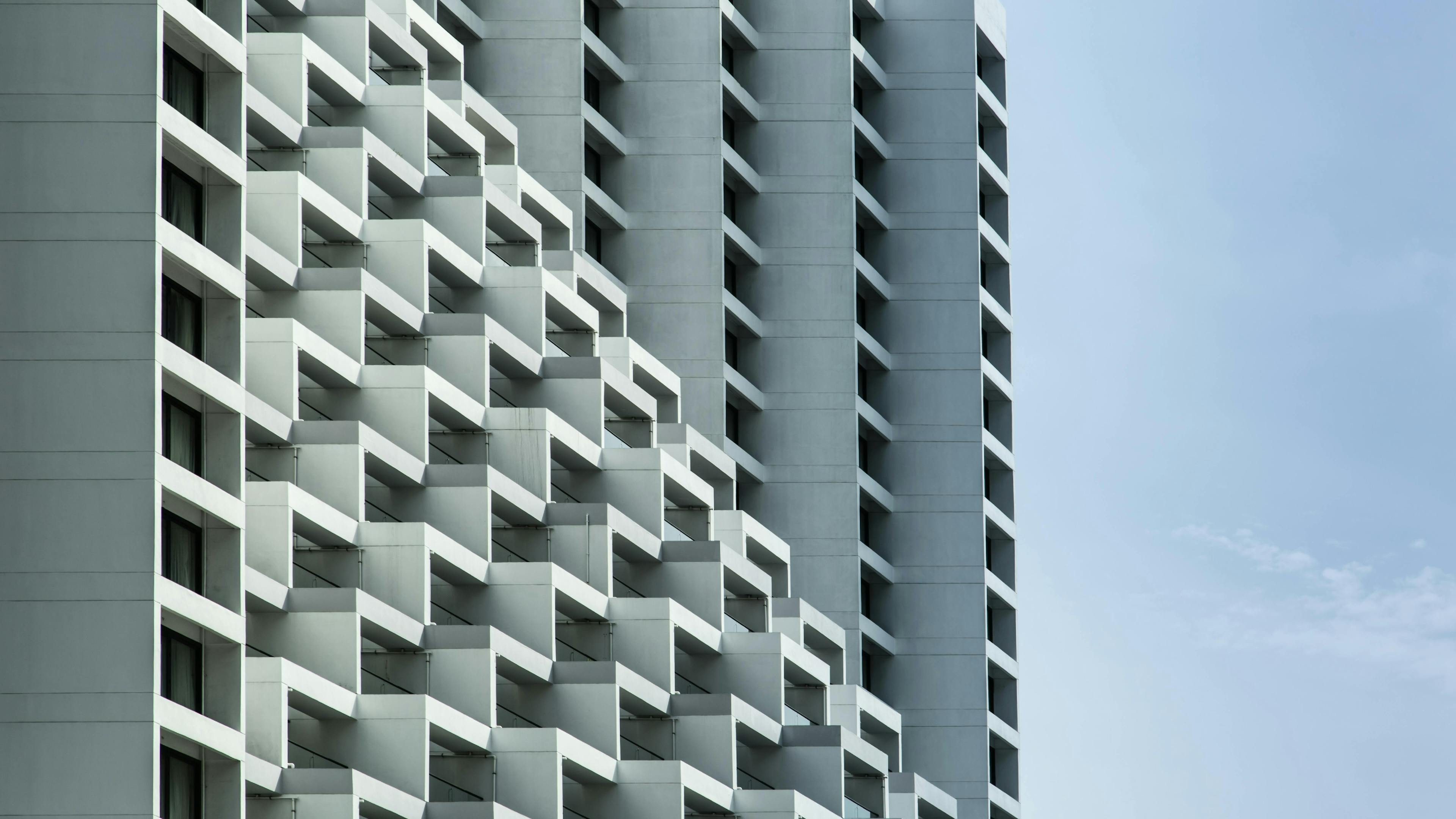 Architectural photograph of two white building with repeating angular details